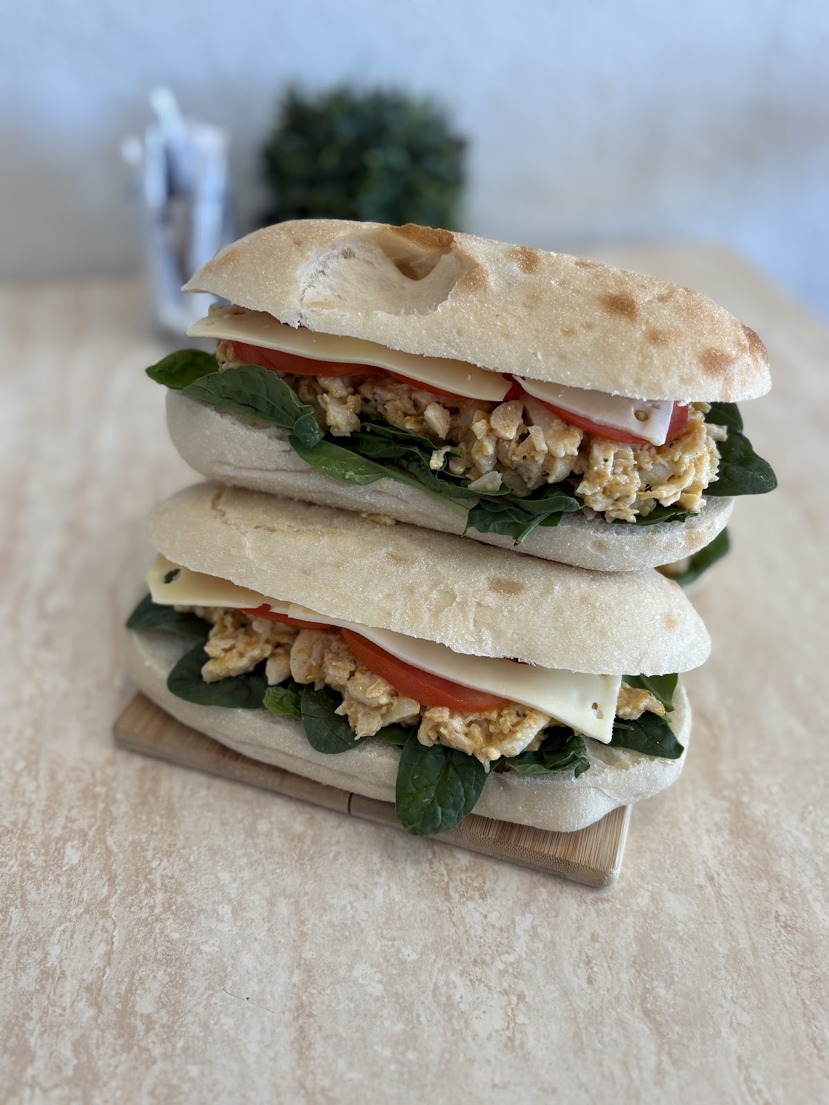 Toasted rolls stacked high with chicken, spinach, tomato and cheese