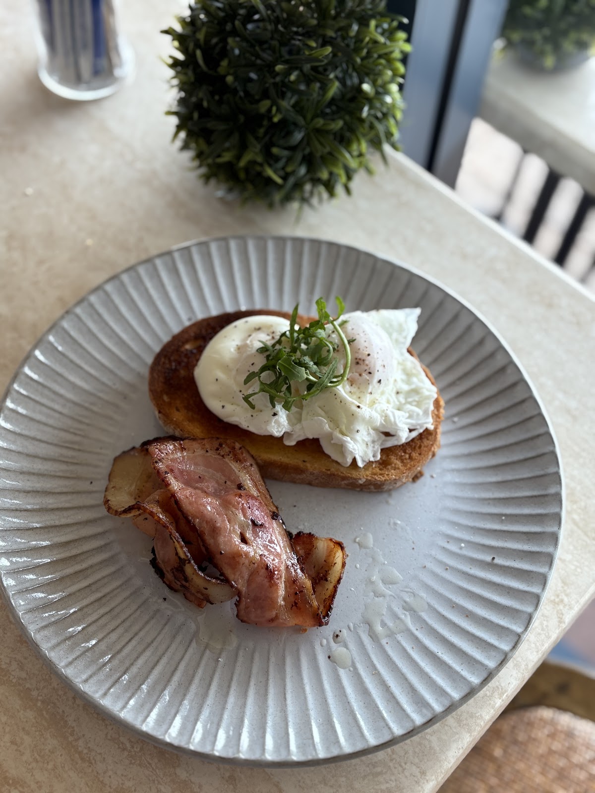 Poached egg on toast with crispy bacon